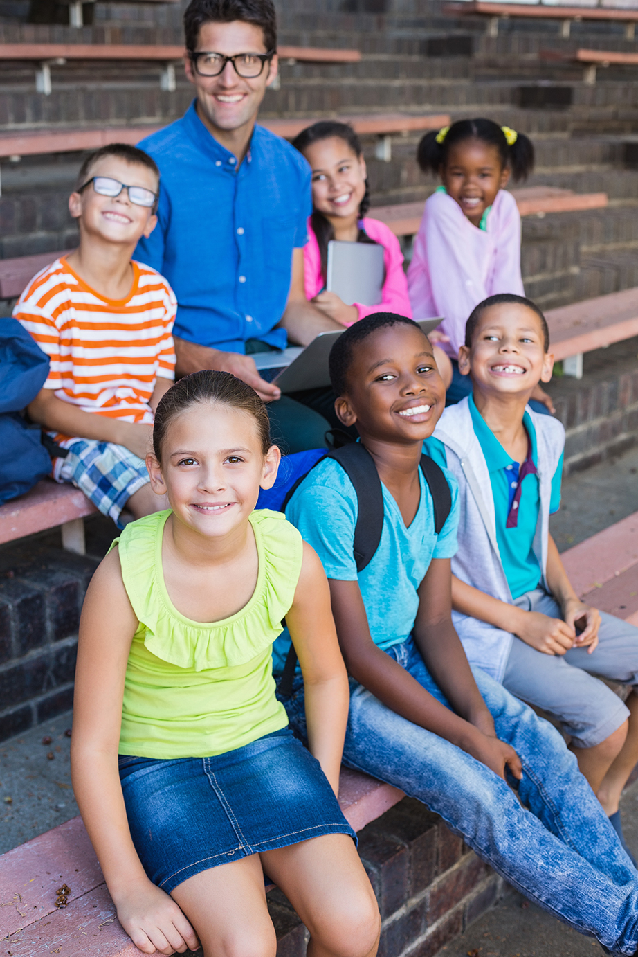 Portrait of teacher and kids sitting on bench teacher and kids sitting on bench